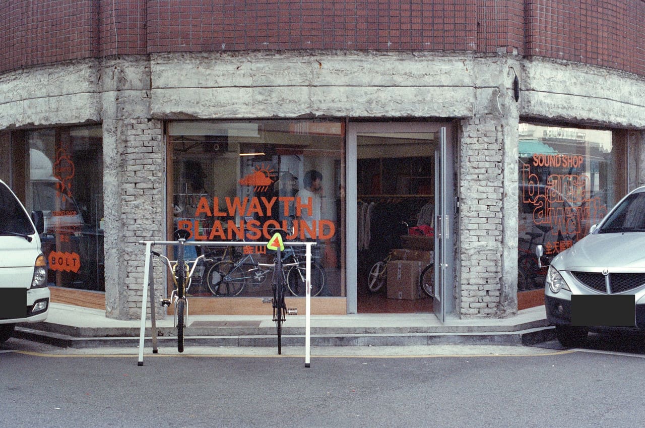 BOLT shopfront with collaboration graphics on the glazing and a bicycle