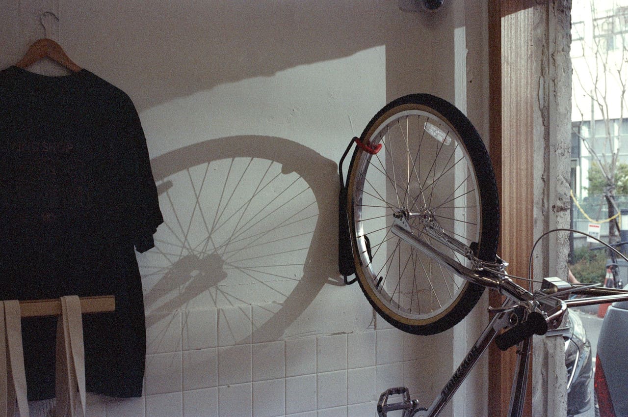 A bicycle wheel and clothing displayed against a tiled wall
