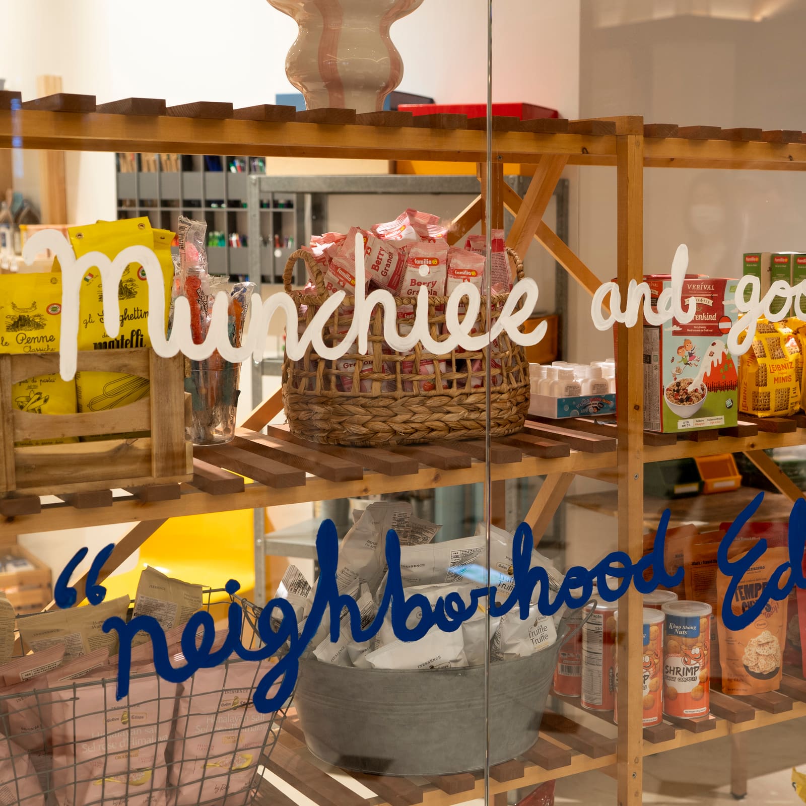 Food display seen through a window lettered NEIGHBORHOOD