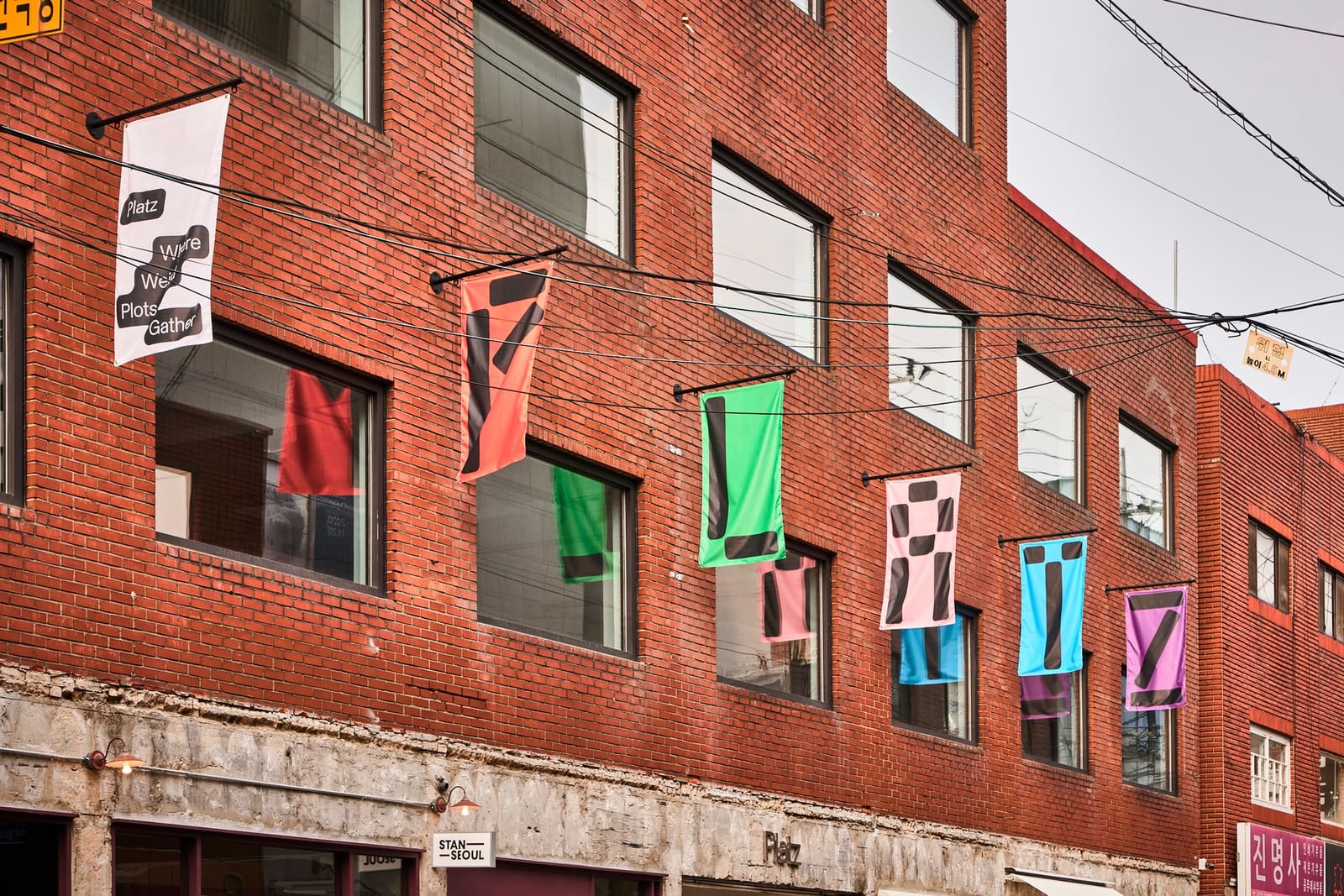 Angled view of a red-brick building with windows in several colors