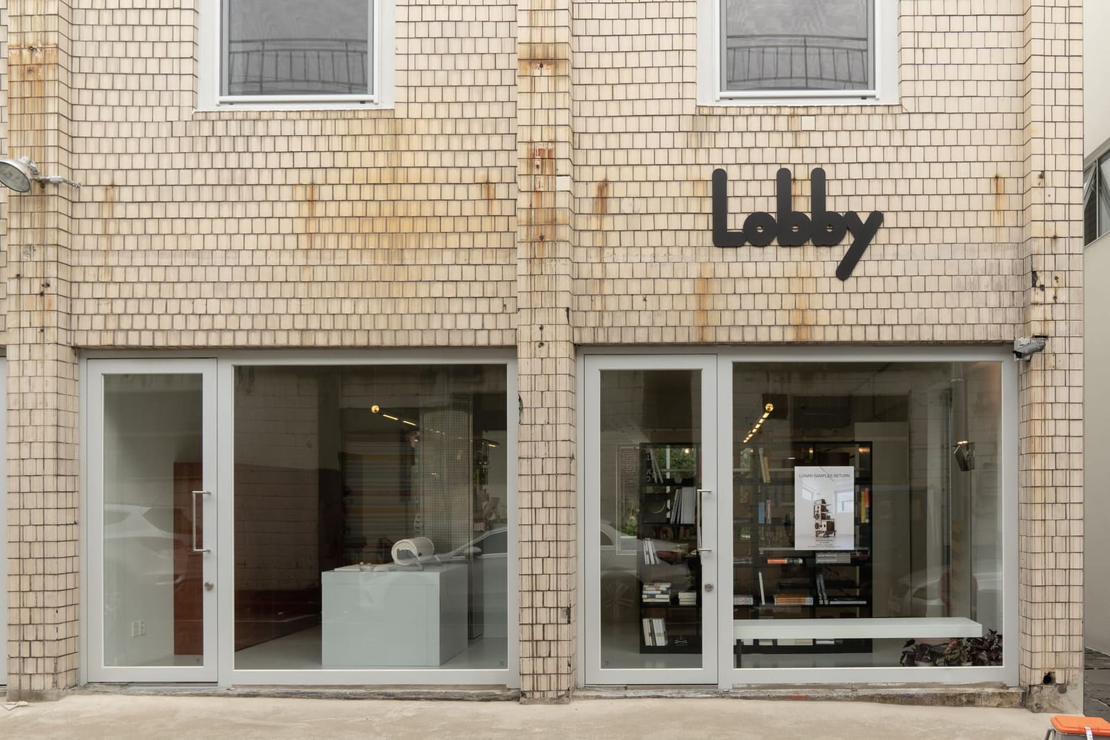 플라츠2 기록 사진: Lobby 사인이 붙은 타일 외벽과 유리 너머 숍 내부