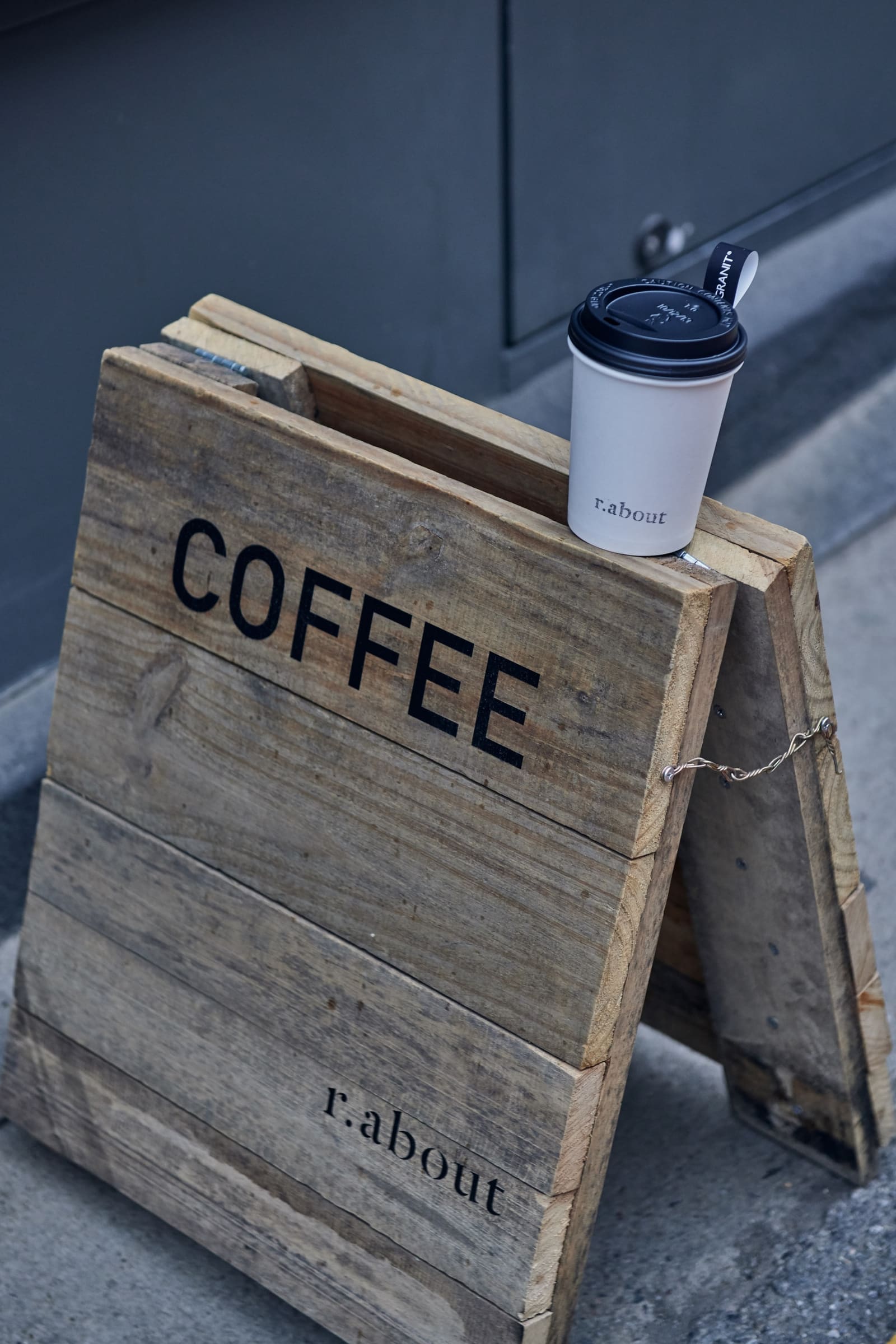 r.about archive: takeaway cup on a wooden sign marked COFFEE
