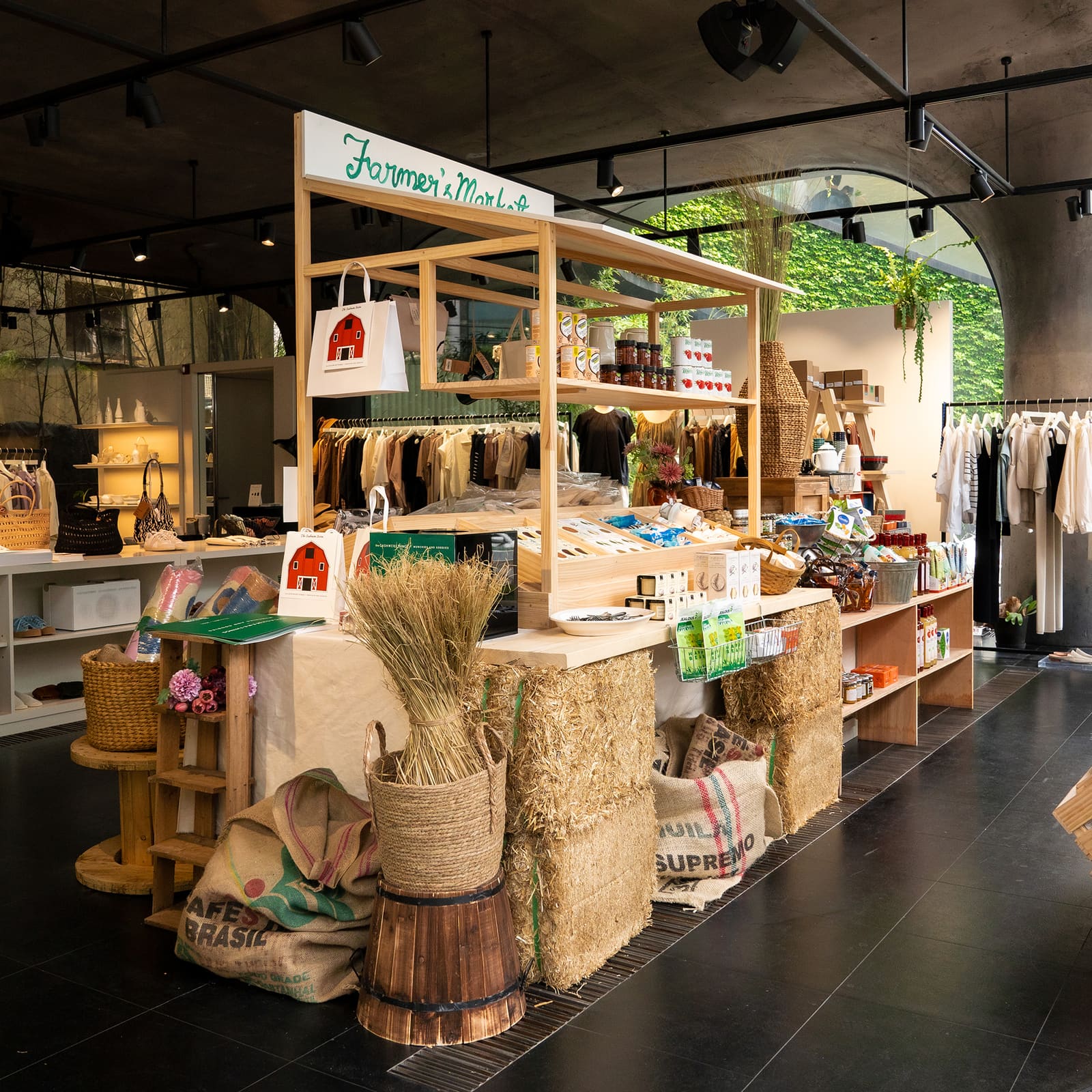 Food and clothing on a wooden display with hay inside the CASHMERE THINGS collaboration pop-up